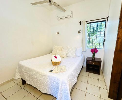 a bedroom with a bed with a basket on it at CABO BOHEMIA Tropical Garden Studios in Cabo San Lucas