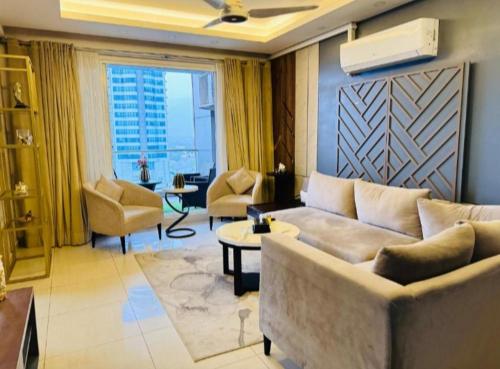 een woonkamer met een bank en stoelen bij LMY Elysium Designer Luxury Apartments Facing Centaurs Mall Islamabad in Islamabad