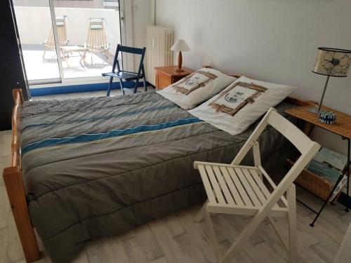 une chambre avec un lit, une chaise et une fenêtre dans l'établissement Résidence Casino - Charmant T3 en plein cœur de la station balnéaire du Val-André. MAE-6444, à Pléneuf-Val-André