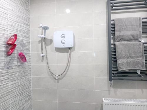 a bathroom with a shower with red shoes and towels at Fenniscourt Cottage in Carlow