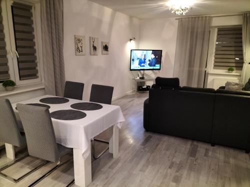 a living room with a white table and a couch at Apartament Ustroń Jaszowiec in Ustroń