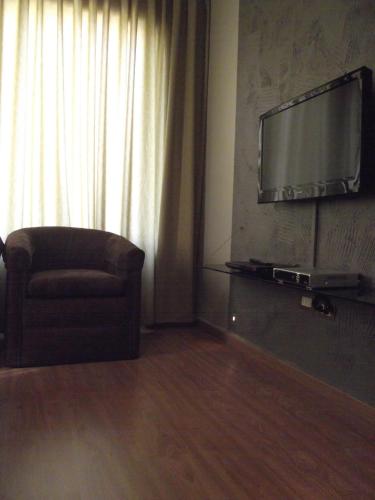 a living room with a chair and a flat screen tv at Crystal Suites in Amman