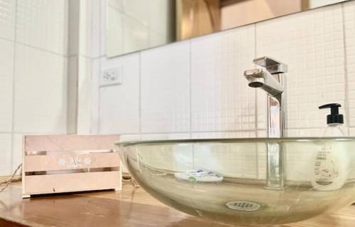 a glass bowl with a faucet on a counter at Chango's Apartments in Bocas del Toro