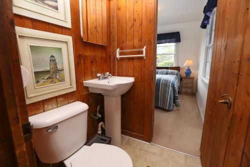 a bathroom with a white toilet and a sink at Clipper - Oceanfront Outer Banks Home with Private Pool - 5BR/3.5BA in Southern Shores