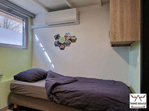 ein kleines Schlafzimmer mit einem Bett und einem Fenster in der Unterkunft Terre Rouge - Terra Rubica - Les Terrasses de Malmedy in Malmedy