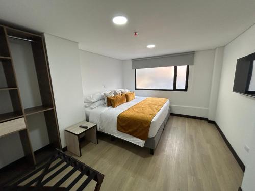 a bedroom with a bed and a window at Hotel WLH Gold Bogota in Bogotá