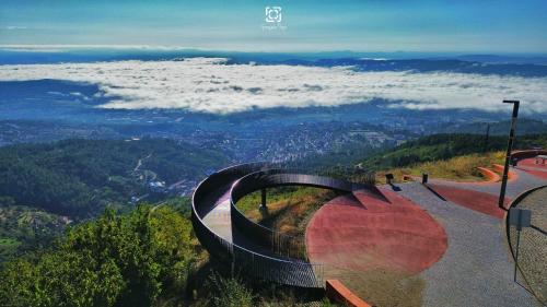 a view from the top of a mountain with clouds at Chalé Zimbro, Serra da Estrela, Penhas da Saúde in Penhas da Saúde