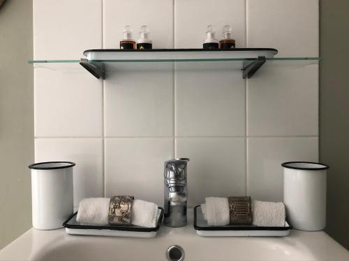 een badkamerbar met handdoeken en een vaas op een plank bij Gite Hotel de maître centre village la Chapelle in Lyons-la-Forêt
