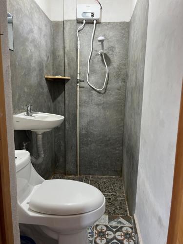 a bathroom with a shower and a toilet and a sink at Casa Madera in San Marcos La Laguna