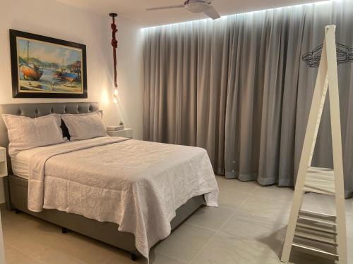 une chambre avec un lit et un ventilateur de plafond dans l'établissement Casa linda em Unamar!, à Cabo Frio