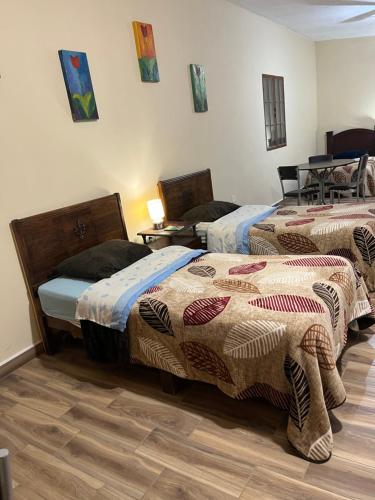 a room with two beds with blankets on them at Finca Campestre Los Pinos in Arteaga