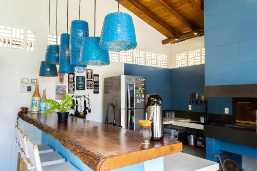 サンタ・クルース・カブラーリアにあるSuite DAVI - Guest House Guaiuの青いペンダントライトとカウンター付きのキッチン