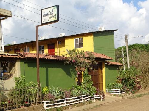 un edificio giallo e verde con un cartello di fronte di Hostal Juarez Ataco a Concepción de Ataco