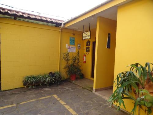 un edificio giallo con una fila di piante in vaso di Hostal Juarez Ataco a Concepción de Ataco