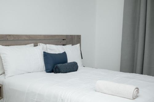 a large white bed with two towels on it at Hidas serviced apartments in Windhoek