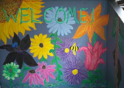 a painting of flowers on a wall with the word welcome at Lil Black Bear Inn in Nashville