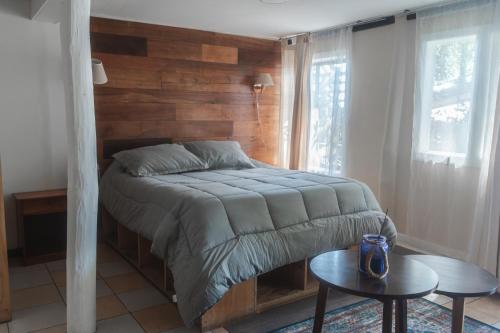 a bedroom with a bed with a wooden wall at Cabañas El Bosque in Maitencillo
