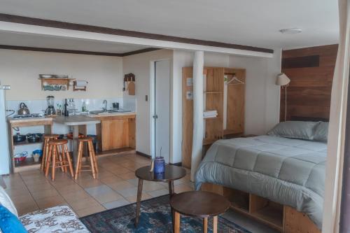a small bedroom with a bed and a kitchen at Cabañas El Bosque in Maitencillo