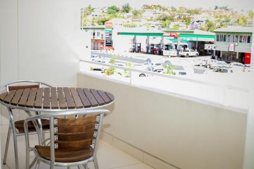 a table and chairs on a balcony with a view of a city at Hidas serviced apartments in Windhoek