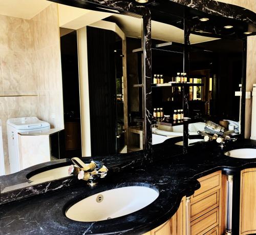 uma casa de banho com 2 lavatórios e um espelho grande em le lodge Saint Clair em Sète