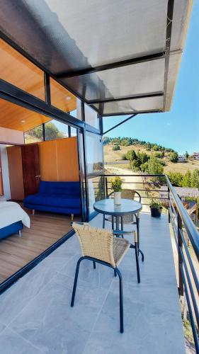 a balcony with a table and a bed at Cabañas los Sauces in Tota
