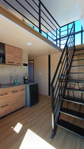 a kitchen with a spiral staircase in a house at Cabañas los Sauces in Tota