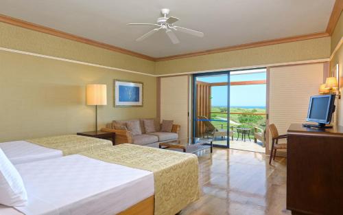 a bedroom with a bed and a couch and a television at Lykia World Links Golf Antalya in Denizyaka