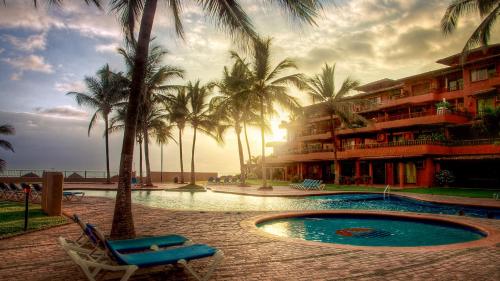 a resort with a swimming pool and palm trees at 15 - 139 B Stunning Oceanview Dept in Los Tules in Puerto Vallarta