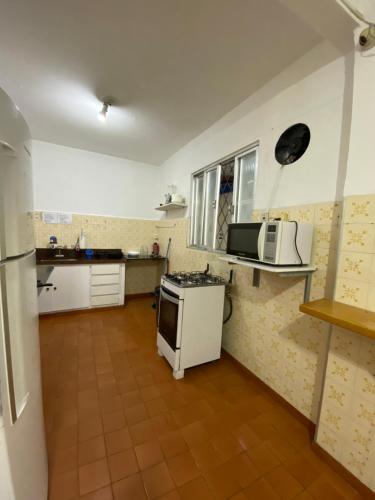 a kitchen with a stove and a microwave at HOSTEL DA VILA in Santos