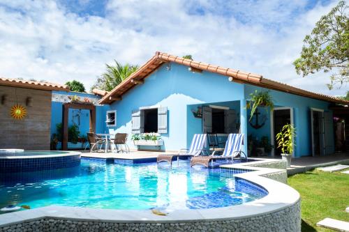 uma villa com piscina em frente a uma casa em Suite LIAM - Guest House Guaiu em Santa Cruz Cabrália