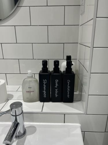 a shelf with three bottles ofodorizers on a bathroom sink at New Peaceful Luxury Home with free ParkingWiFi Sheffield in Sheffield