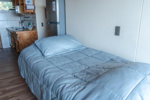 a large bed in a room with a kitchen at Cabañas El Bosque in Maitencillo