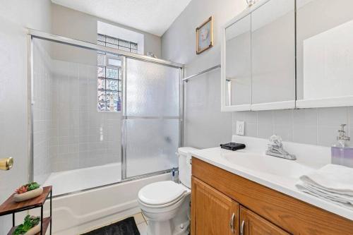 a bathroom with a toilet and a shower and a sink at 3 King Beds/3Baths Spacious in Soulard
