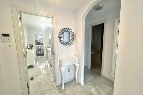 Baño blanco con lavabo y espejo en MI CAPRICHO Beachfront 400 - Apartment With Sea Views Costa del Sol, en Mijas Costa
