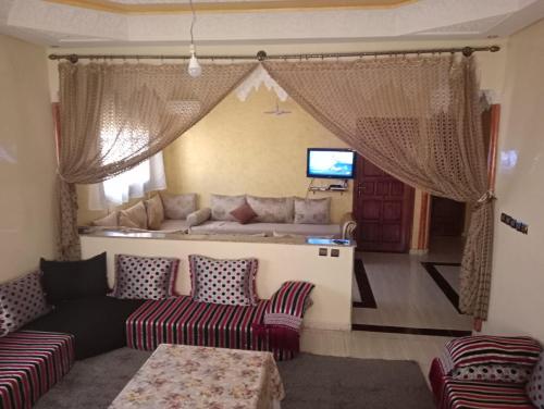 ein Wohnzimmer mit einem Sofa und einem TV in der Unterkunft Maison a louer par jour pour familles in Meknès