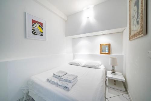 une chambre blanche avec un lit avec des serviettes dessus dans l'établissement Nice 2-3 bedroom ideally located, à Cannes