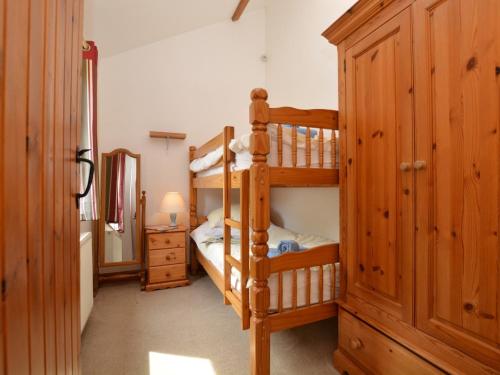 a bedroom with two bunk beds and a mirror at 2 Bed in Sherborne FOLKI in Long Burton