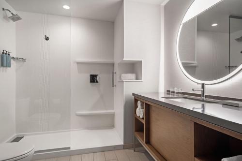 a bathroom with a shower and a sink and a mirror at Courtyard by Marriott Marina del Rey in Los Angeles