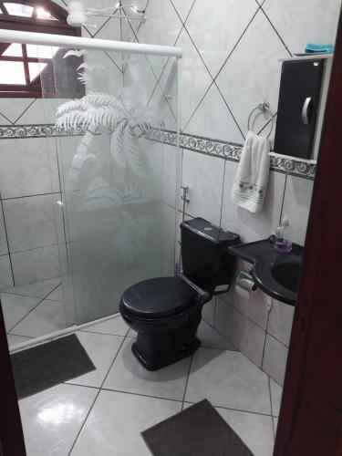 a bathroom with a black toilet and a sink at Guarus house plaza shopping in Campos dos Goytacazes