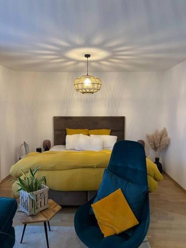 a bedroom with a yellow bed and a chair at Warm apartment + private free park. in Vétraz-Monthoux