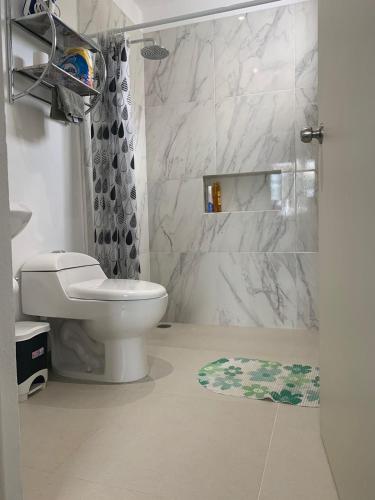 a white bathroom with a toilet and a shower at CASA JARDIN in Cancún