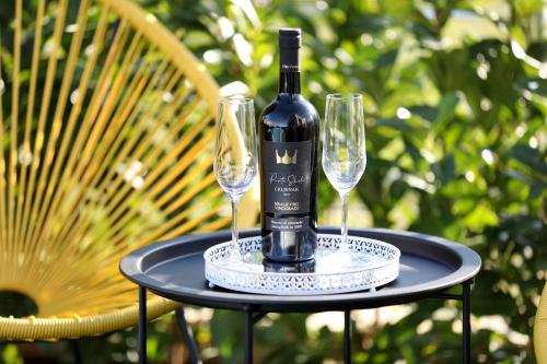 a bottle of wine sitting on a table with two glasses at Orchid Stay in Dobropoljana