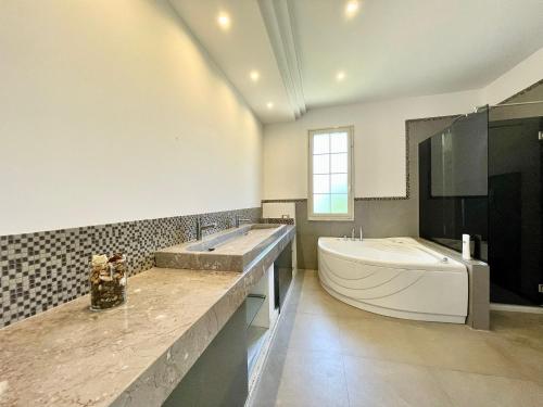 a bathroom with a large tub and a sink and a tub at Villa Rachele con piscina in Balestrate
