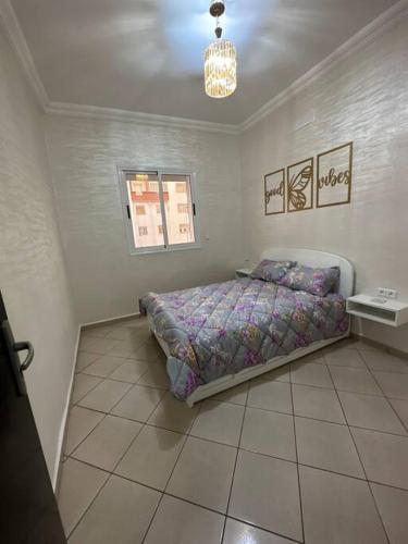 a bedroom with a bed and a table in it at Appartement de lux à agadir in Agadir
