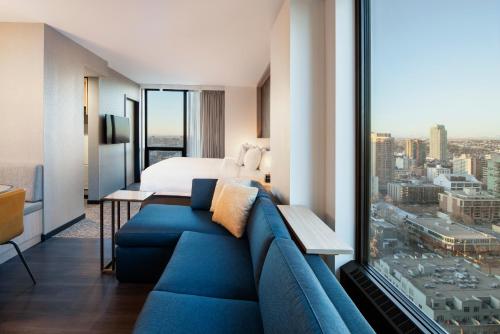 Habitación de hotel con sofá azul y cama en Residence Inn by Marriott Calgary Downtown/Beltline District en Calgary