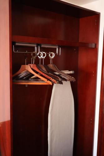 a closet with a rack with a curtain and shoes at Dreamtel London Kensington in London