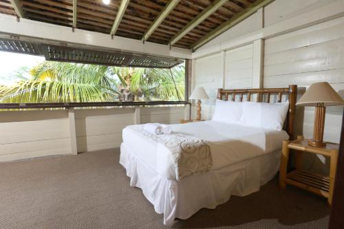 a bedroom with a bed and a large window at Strawberry Fields Together in Robins Bay
