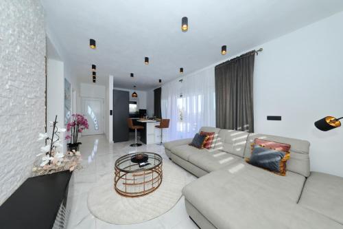 a living room with a white couch and a table at Orchid Stay in Dobropoljana