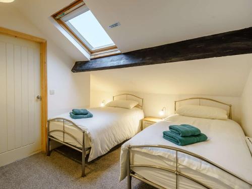 two beds in a bedroom with a skylight at 4 Bed in Broughton - in - Furness 90412 in Duddon