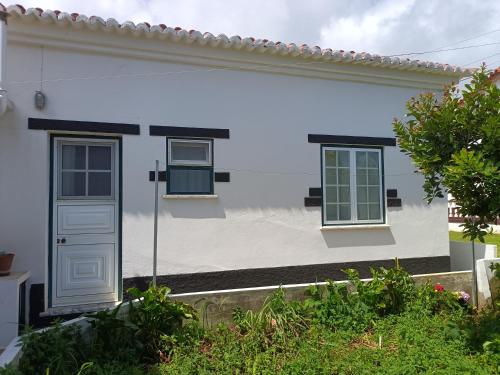 a white house with two windows and a door at Casa da Atalaia in Angra do Heroísmo